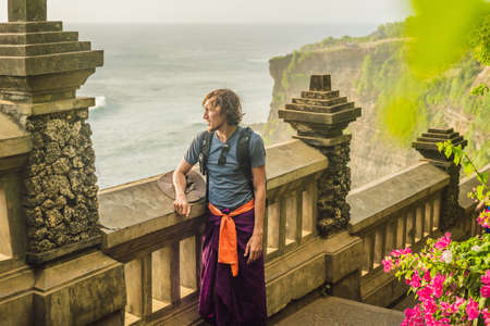 Young man traveler in Pura Luhur Uluwatu temple, Bali, Indonesia.の写真素材