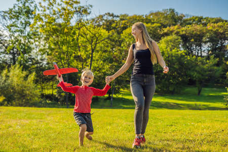Mother and son playing with a large model toy aeroplane in the park.の写真素材