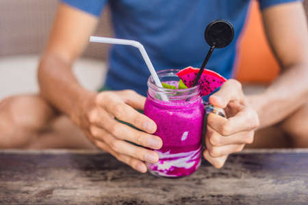 Smoothies made from purple dragon fruit in hands.の写真素材