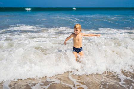 boy playing on the beach in the water.の写真素材