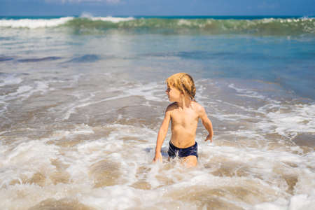 Boy playing on the beach in the water.の写真素材