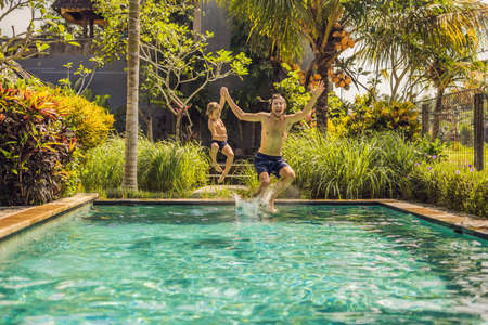 Young father with little son playing in the pool.の写真素材