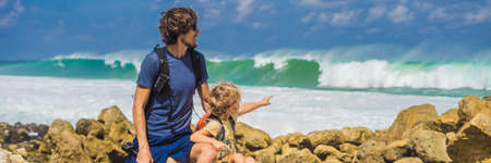 Dad and son travelers on amazing Melasti Beach with turquoise water, Bali Island Indonesia.