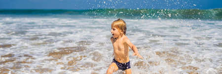 Boy playing on the beach in the water.の写真素材
