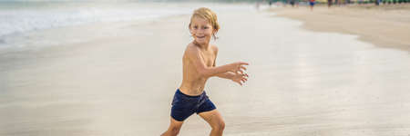 Boy playing on the beach in the water.の写真素材