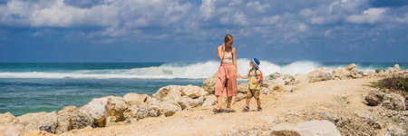 Mom and son travelers on amazing Melasti Beach with turquoise water, Bali Island Indonesia.の写真素材
