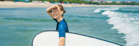Young woman in swimsuit with surf for beginners ready to surf.の写真素材