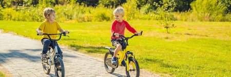 Two happy boys cycling in the park.の写真素材
