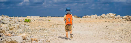 Boy traveler on amazing Melasti Beach with turquoise water, Bali Island Indonesia. Traveling with kids concept.の写真素材