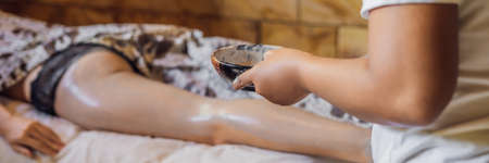 Young woman gets scrub massage in spa salon.の写真素材
