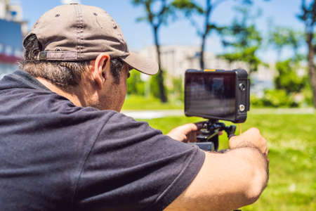 A professional cameraman prepares a camera and a tripod before shooting