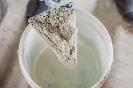 Man making cement with a construction mixer in a bucket.の写真素材