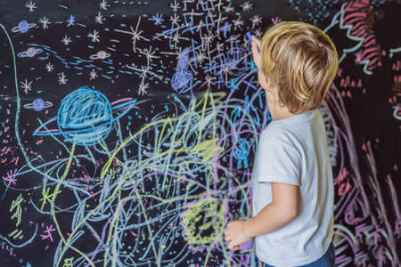 Little boy pointing space, planets and stars on the wall.の写真素材