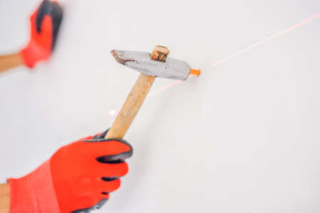 Man twists a screw into the wall.の写真素材