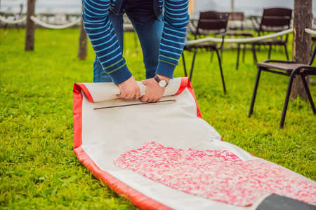 A man blows and collapses SUP A man blows and collapses SUP. Leisure and outdoor sports concept.