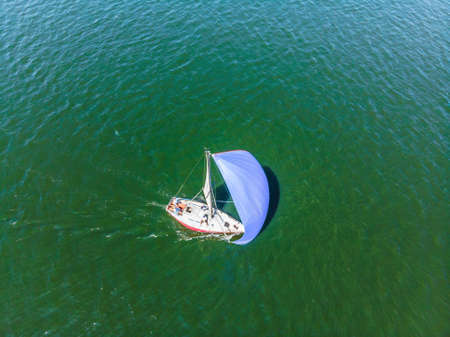 Sailboat shot from above showing the clear blue water of the oceanの写真素材