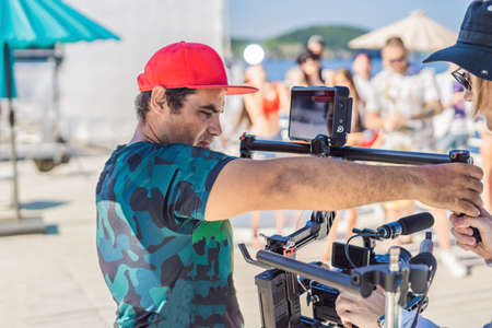 Professional steadicam operator uses a 3-axis camera stabilizer system on a commercial production...