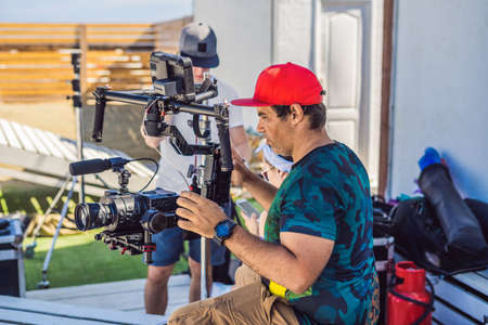 Steadicam operator and his assistant prepare camera and 3-axis stabilizer-gimbal for a commercial...