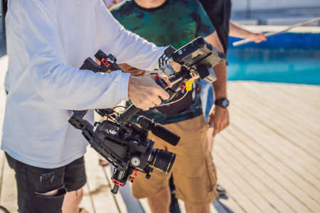 Professional steadicam operator uses a 3-axis camera stabilizer system on a commercial production setの写真素材