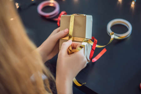 Young woman is packing presents.