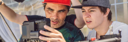 Production team on a commercial video shoot. Steadicam operator uses the 3-axis camera stabilizer and cinema-grade cameraの写真素材