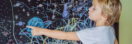 Little boy pointing space, planets and stars on the wallの写真素材