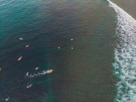 Surfers on the waves in the ocean, top view