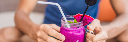 Smoothies made from purple dragon fruit in hands. BANNER, LONG FORMATの写真素材