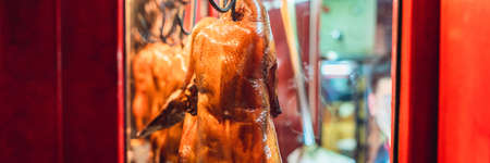 Peking duck is roasting in the oven, preparing to serve on the costの写真素材