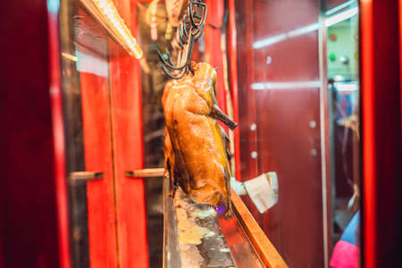 Peking duck is roasting in the oven, preparing to serve on the costの写真素材
