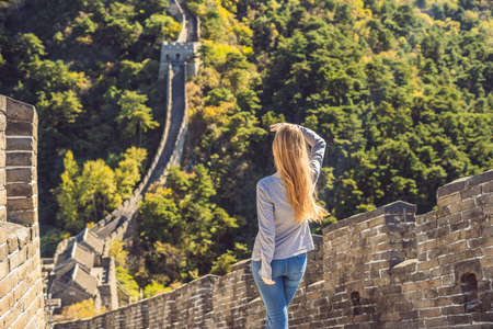 Happy cheerful joyful tourist woman at Great Wall of China having fun on travelの写真素材