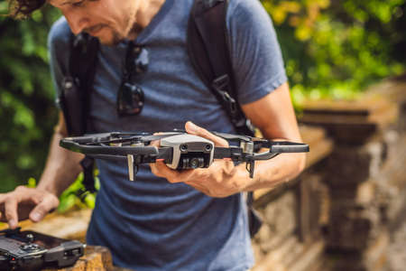 Young man launches a drone into the sky. The island of Bali