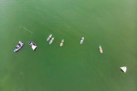 Strong men floating on a SUP boards in a beautiful bay on a sunny day.の写真素材