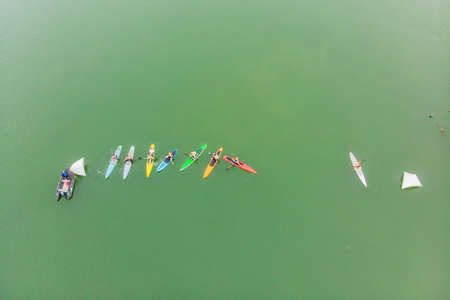 Strong men floating on a SUP boards in a beautiful bay on a sunny day.