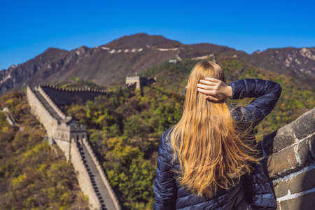 Happy cheerful joyful tourist woman at Great Wall of China having fun on travelの写真素材