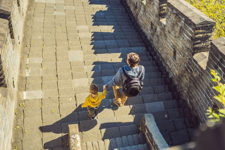 Happy cheerful joyful tourists dad and son at Great Wall of China having fun on travelの写真素材