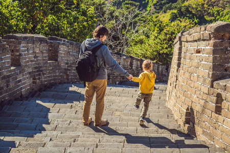 Happy cheerful joyful tourists dad and son at Great Wall of China having fun on travelの写真素材