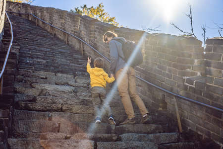 Happy cheerful joyful tourists dad and son at Great Wall of China having fun on travel