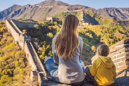 Happy cheerful joyful tourists mom and son at Great Wall of China meditate on vacation trip in Asia.の写真素材