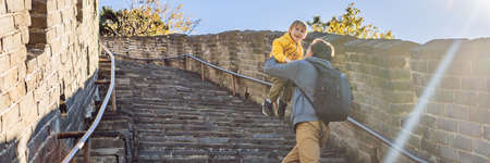 Happy cheerful joyful tourists dad and son at Great Wall of China having fun on travel