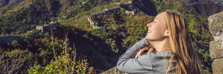 Happy cheerful joyful tourist woman at Great Wall of China having fun on travel smiling laughing and dancing during vacation tripの写真素材