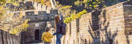 Happy cheerful joyful tourists mom and son at Great Wall of China having fun on travel smiling laughing and dancing during vacationの写真素材