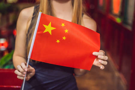 Enjoying vacation in China. Young woman with a Chinese flag on a Chineseの写真素材