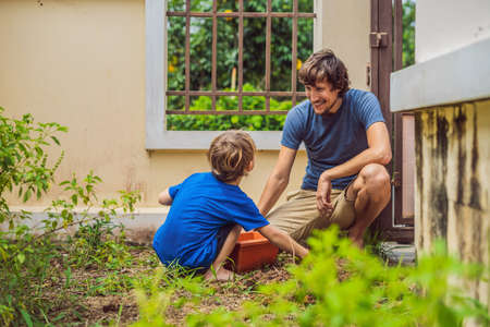 Father and son gardening in the garden near the houseの写真素材