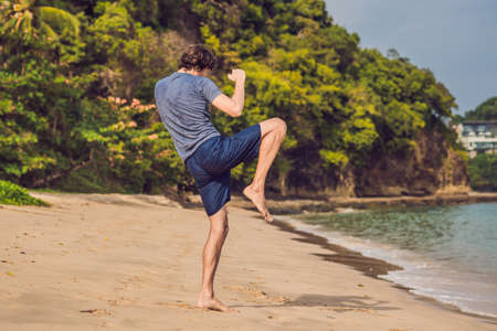young male working out on beach, sporty man doing exercisesの写真素材