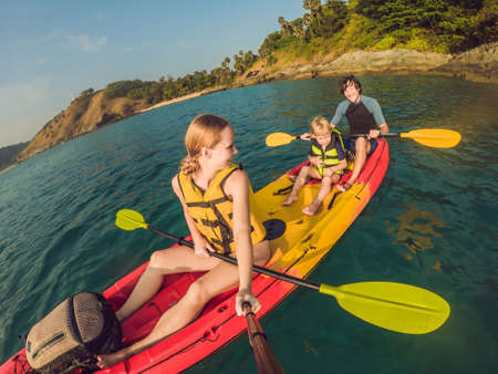 happy family with kid kayaking at tropical oceanの写真素材
