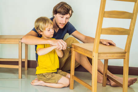 Father and son assembling furniture. Boy helping his dad at home. Happy Family conceptの写真素材