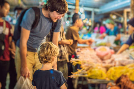 Dad and son are tourists on Walking street Asian food marketの写真素材