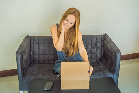 young woman received online shopping parcel opening boxes and buying fashion items by using credit...