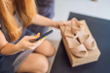 young woman received online shopping parcel opening boxes and buying fashion items by using credit cardの写真素材